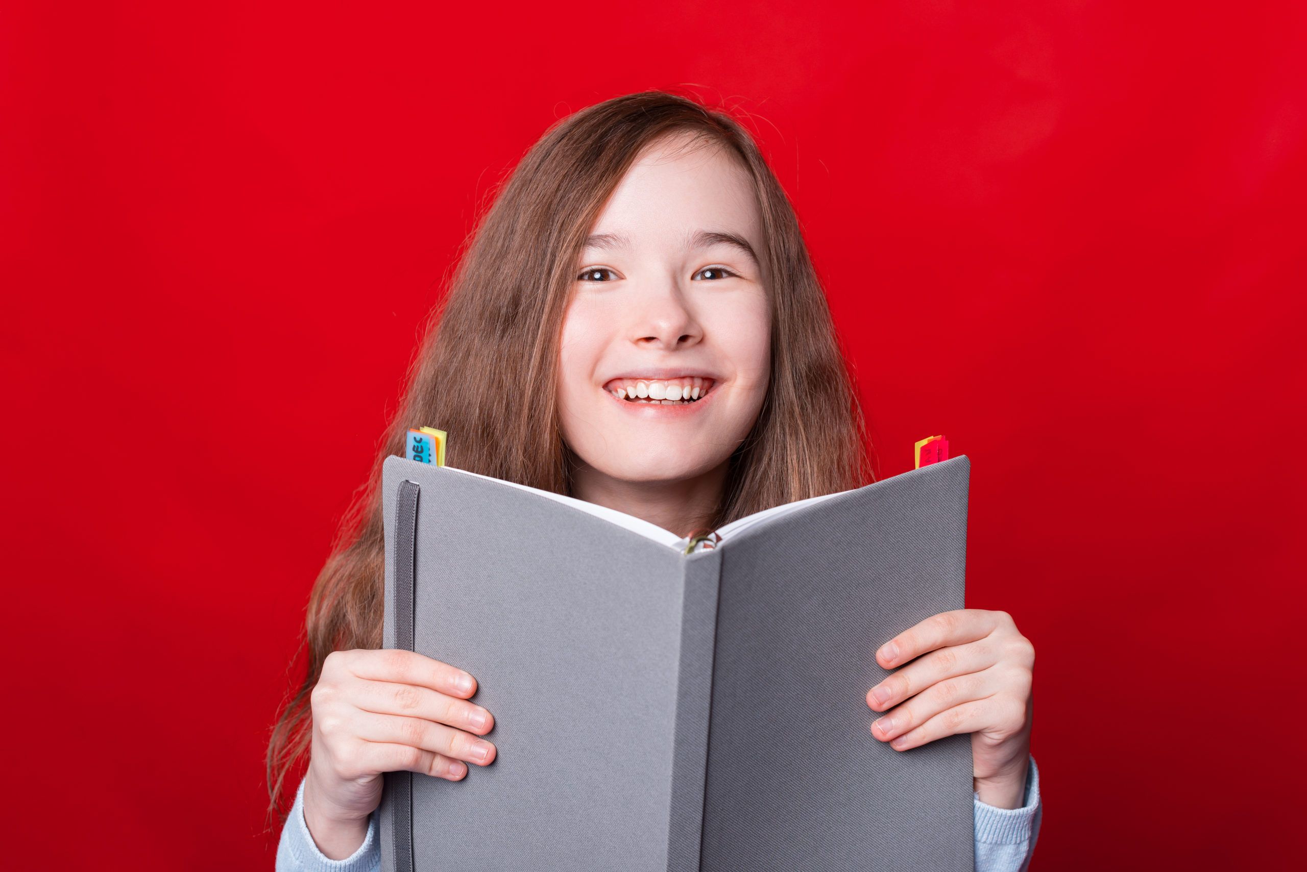 Girl holding a book and showing a happy emotion