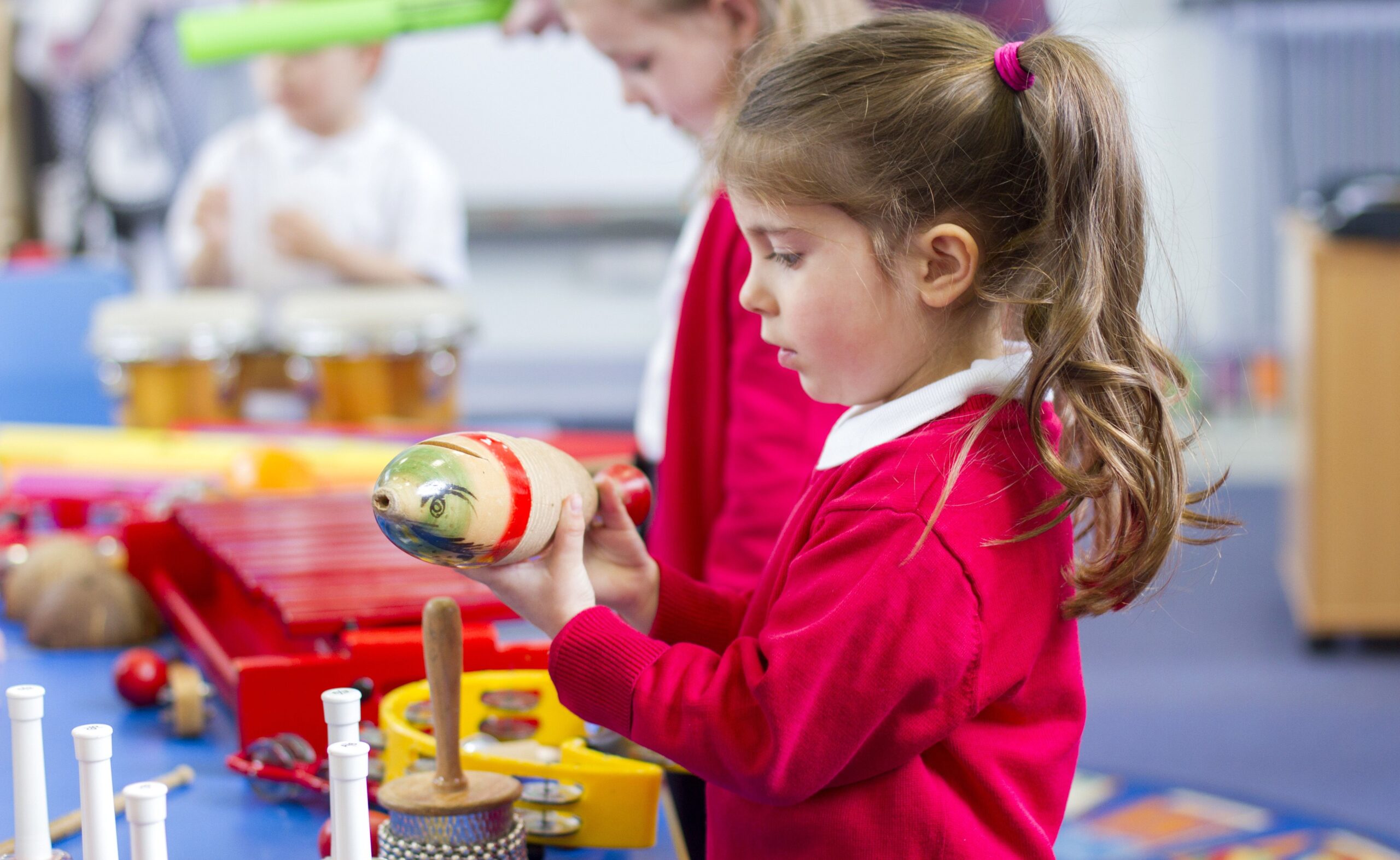 Girl playing maracas in music class