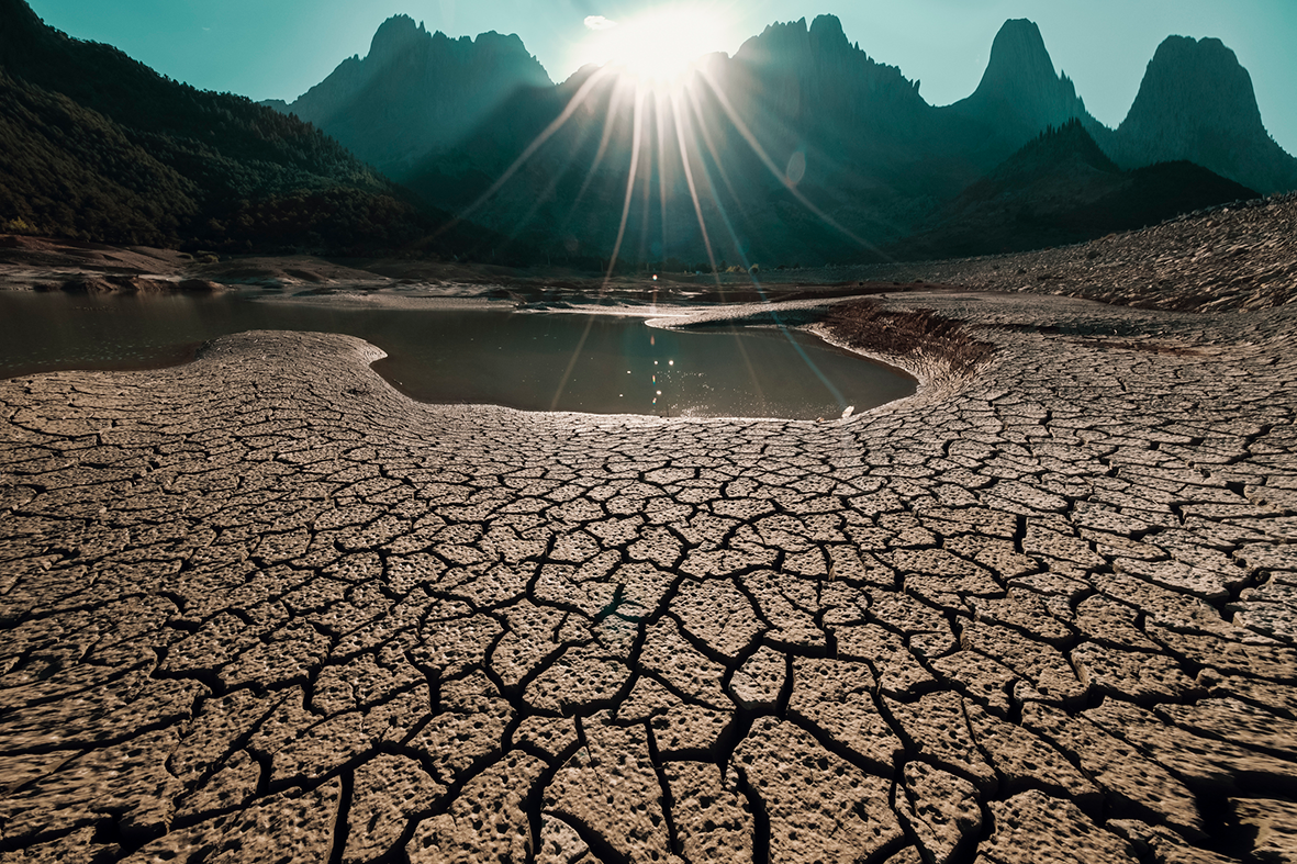 Dry. cracked desert ground with small pool