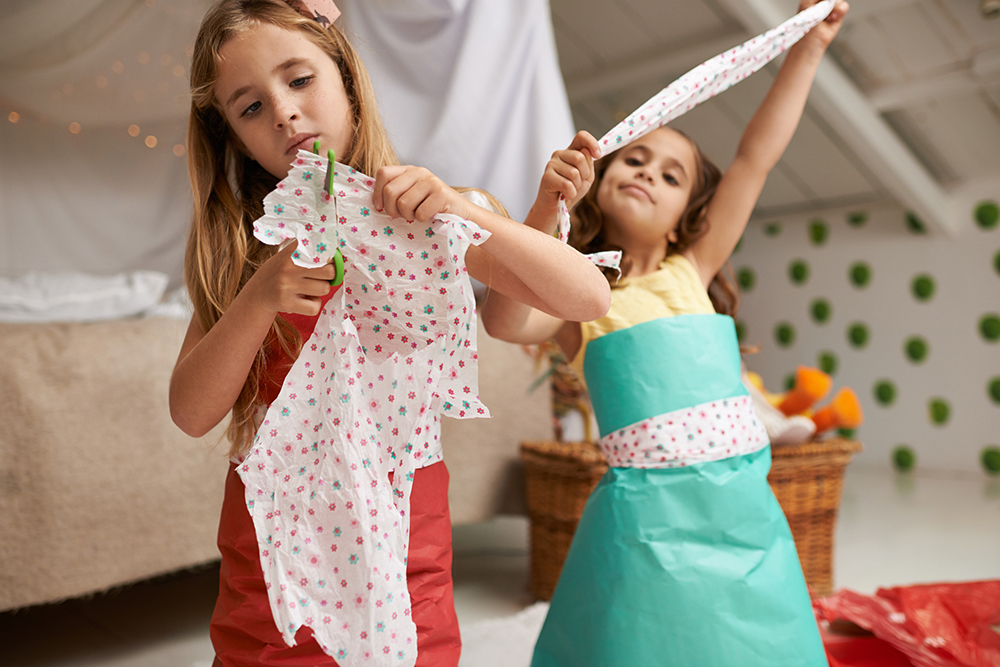 Two girls having fun making dresses