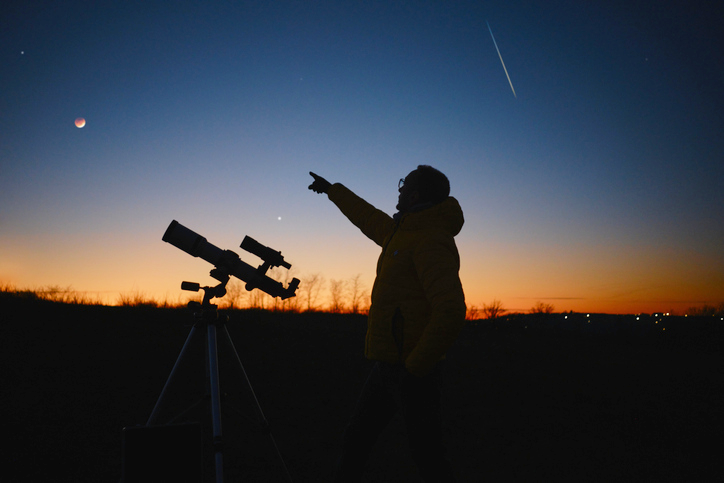 Astronomer with a telescope viewing the night sky