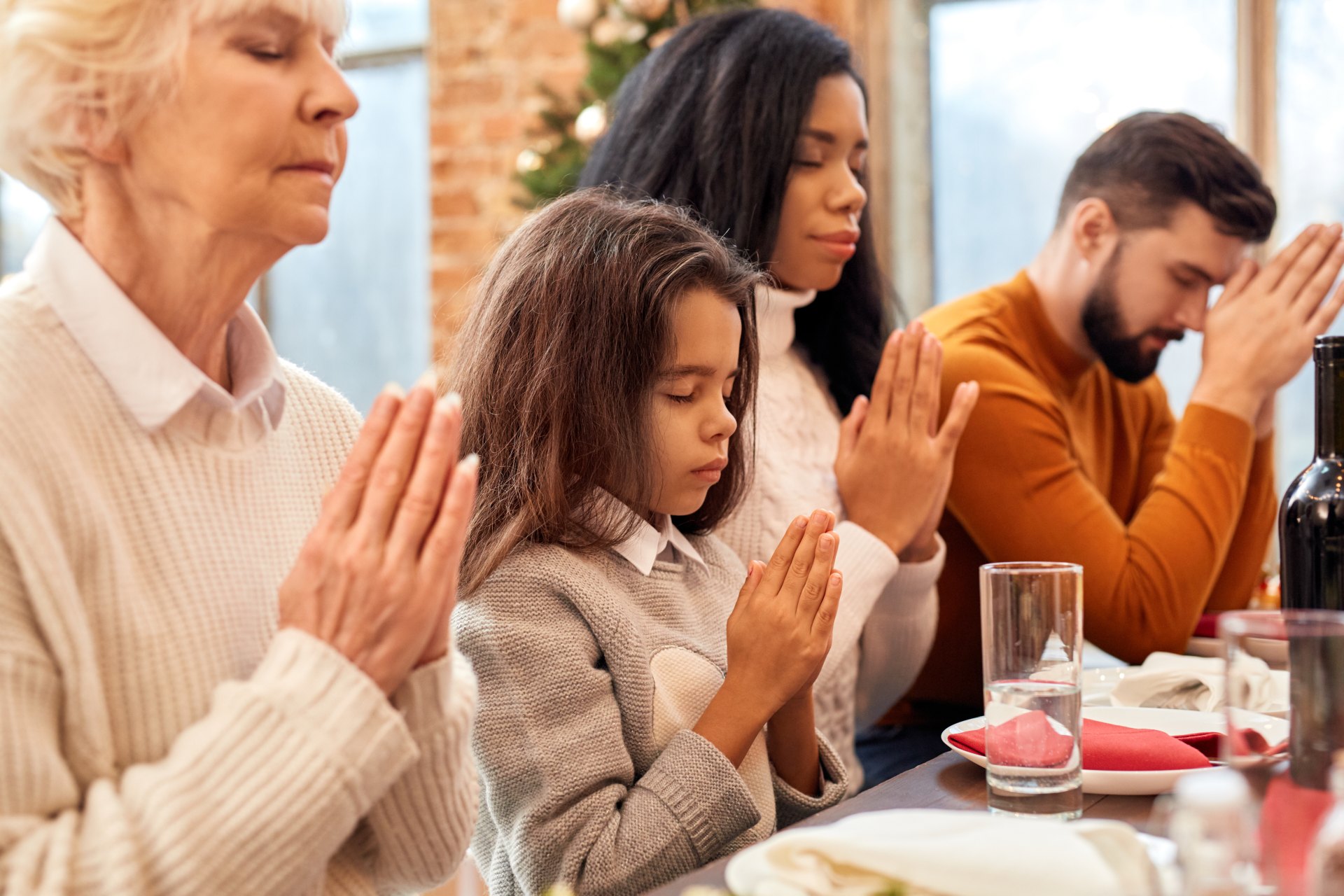 Family praying together before eating.