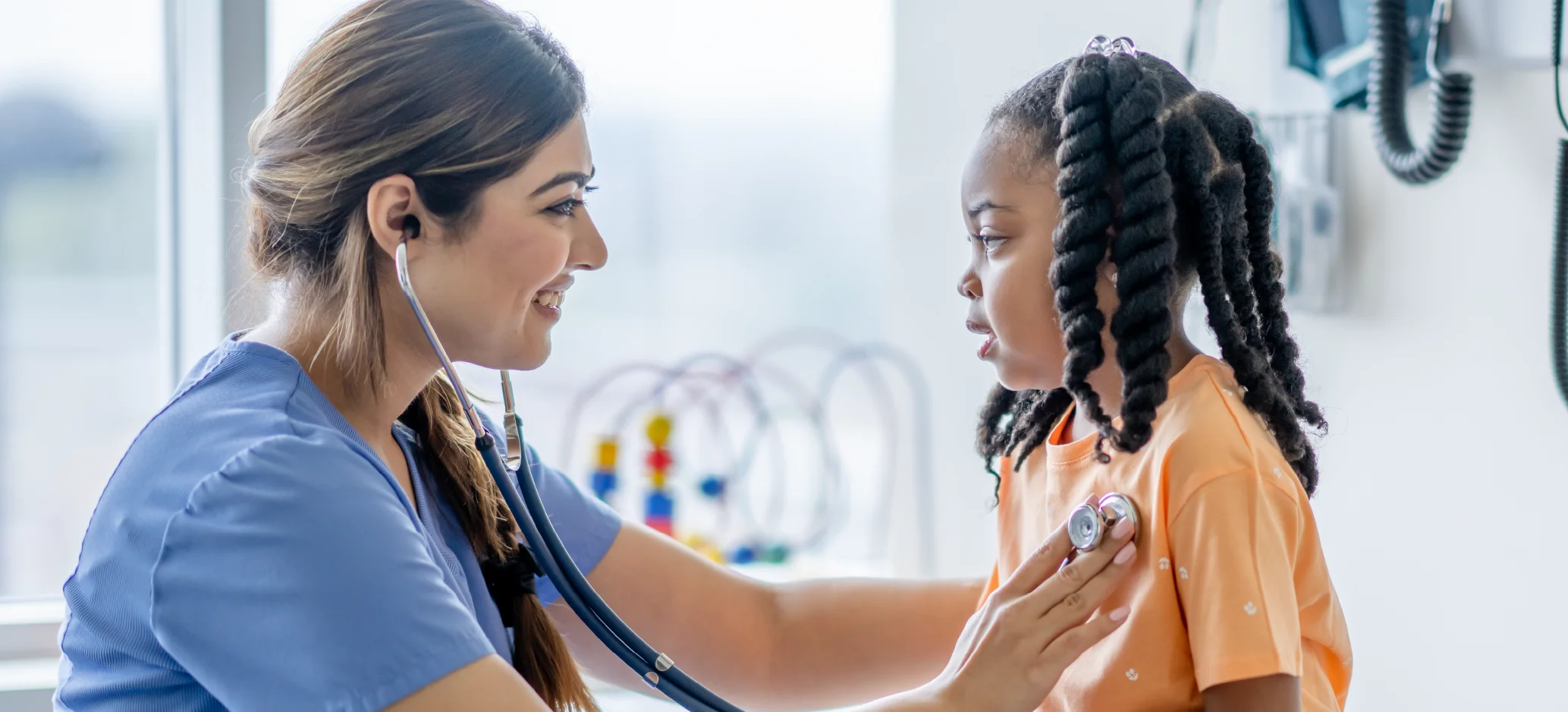 Nurse listening to a child’s chest with a stethoscope during a check-up