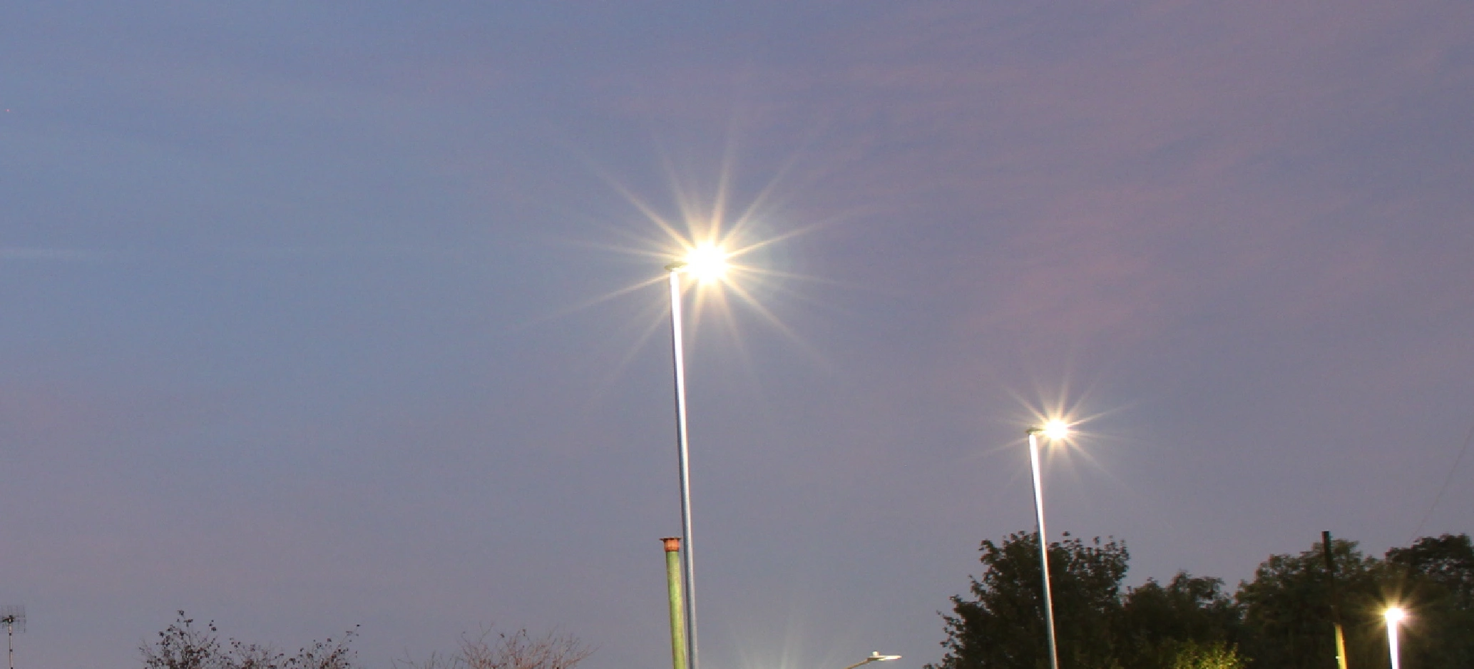 A row of streetlights at dusk.