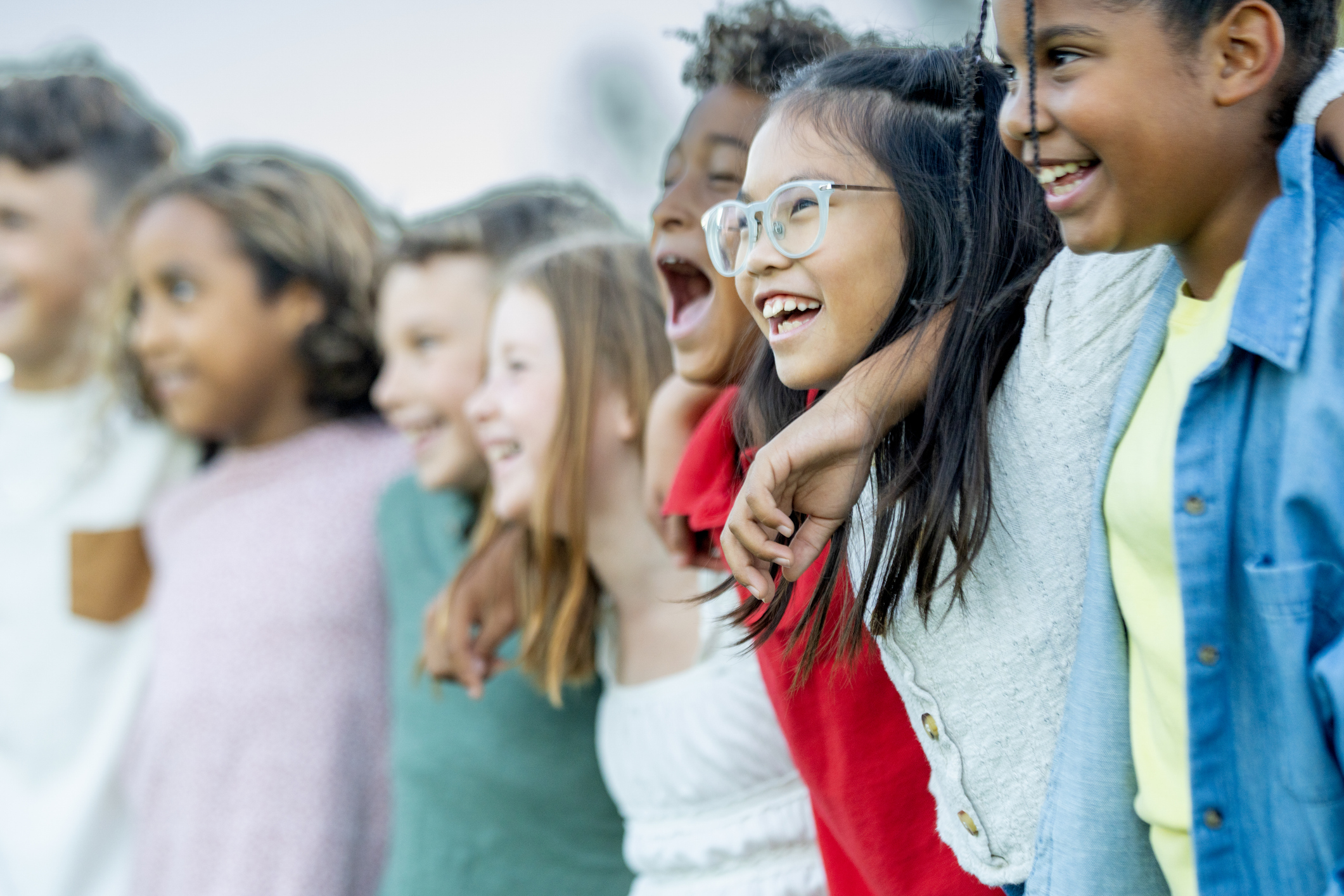 Diverse Group Of Kids Laughing Together Outdoors, Friends Arm In Arm, Shared Happiness