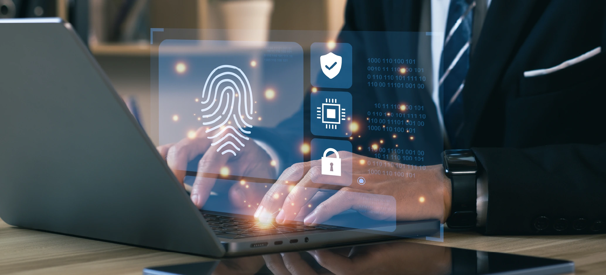 A person using a laptop with digital security symbols, including a fingerprint and padlock.