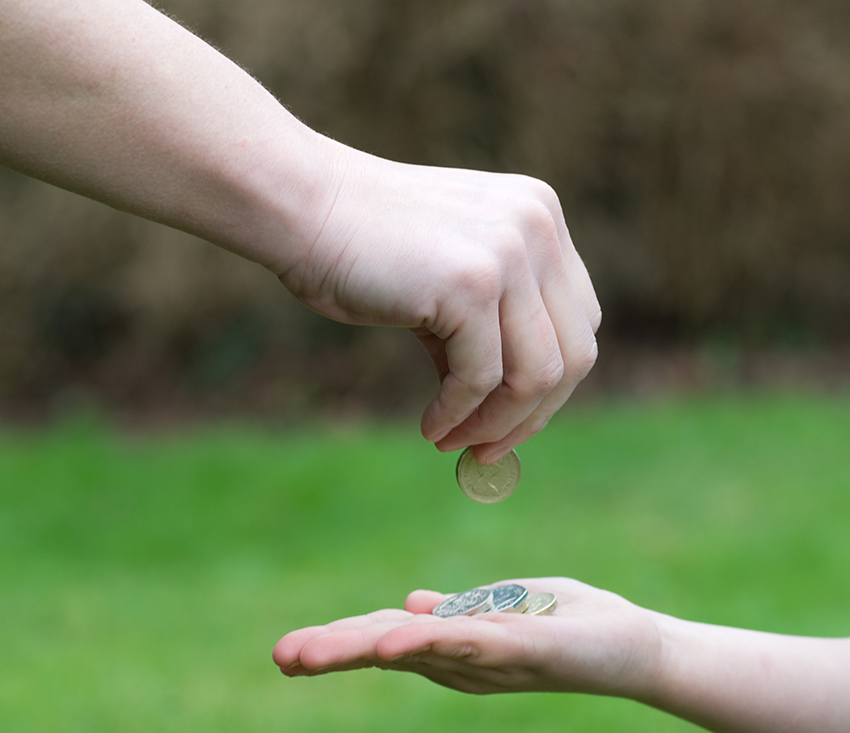 A person handing coins to another person.