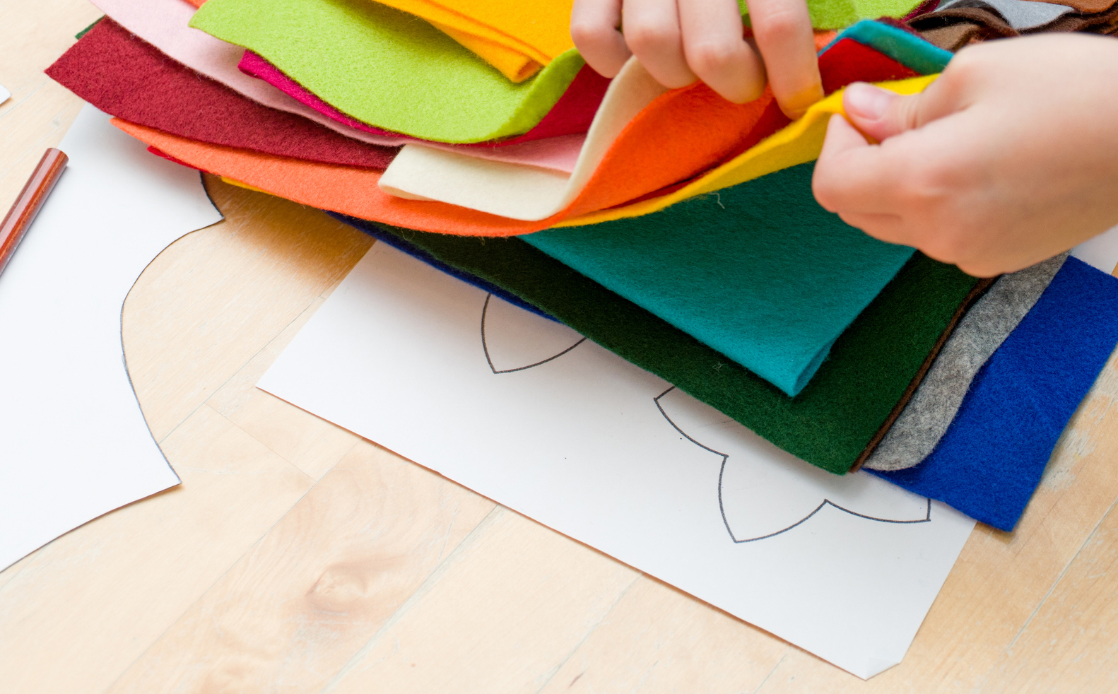 Child choosing fabric amongst a pile of colours.