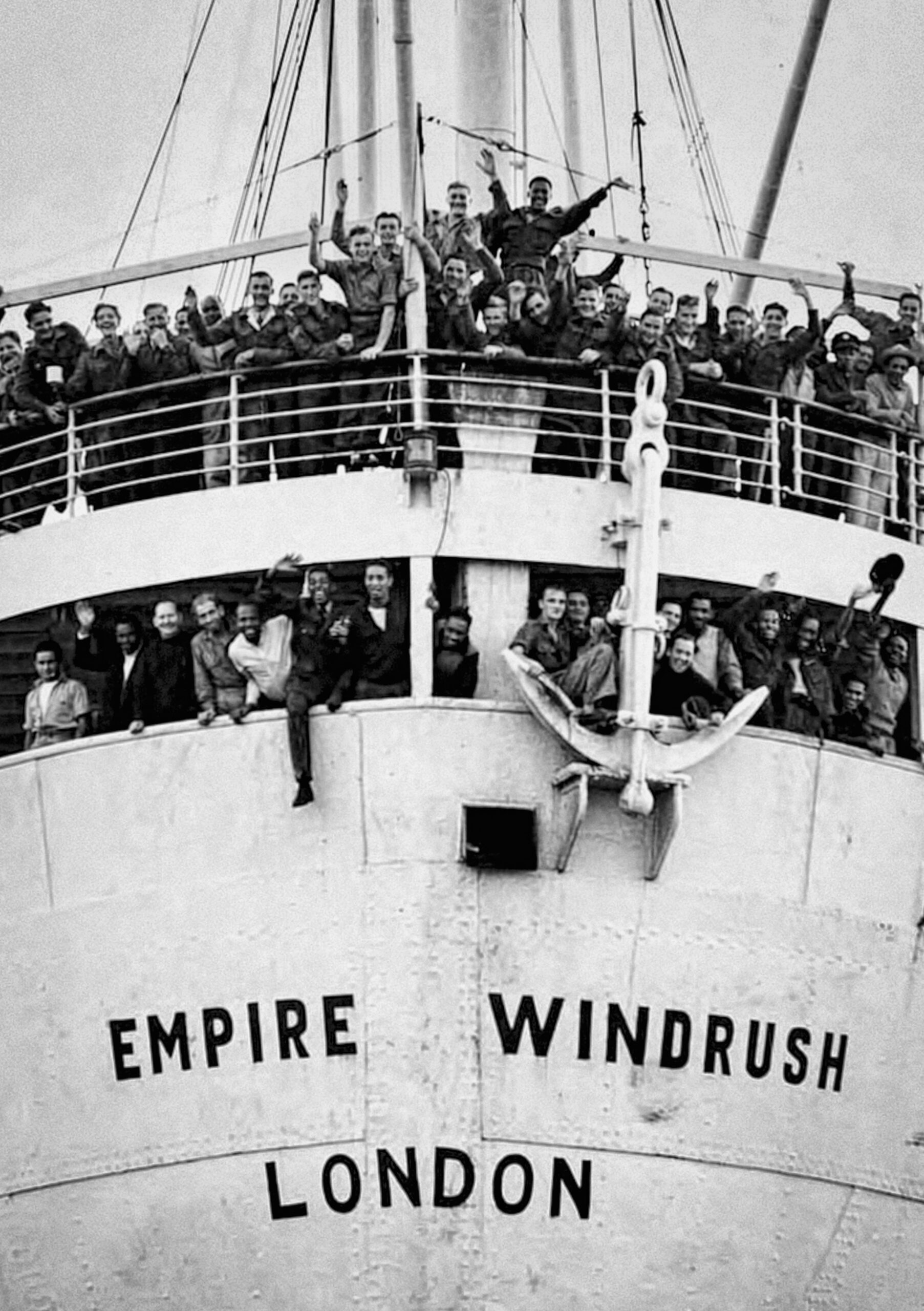 Passengers aboard the Empire Windrush wave from the ship’s deck on arrival in London.