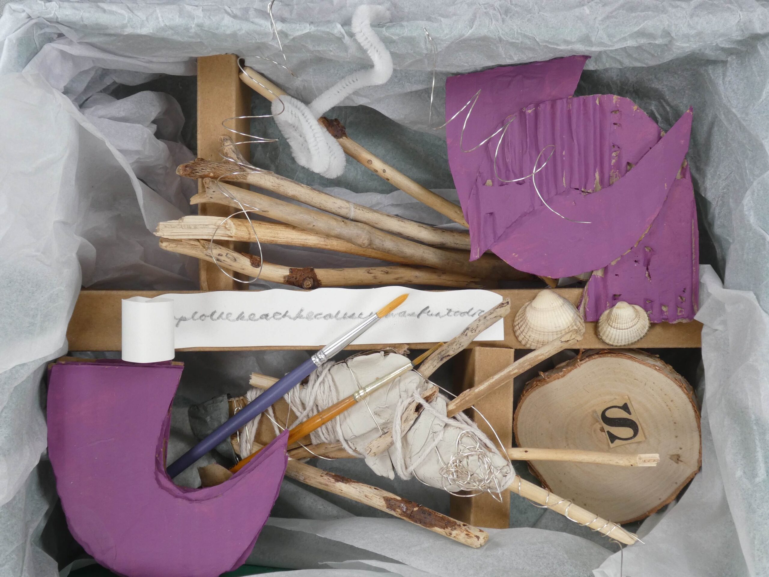 The inside of an example box sculpture, filled with objects, text and abstract shapes to convey memories