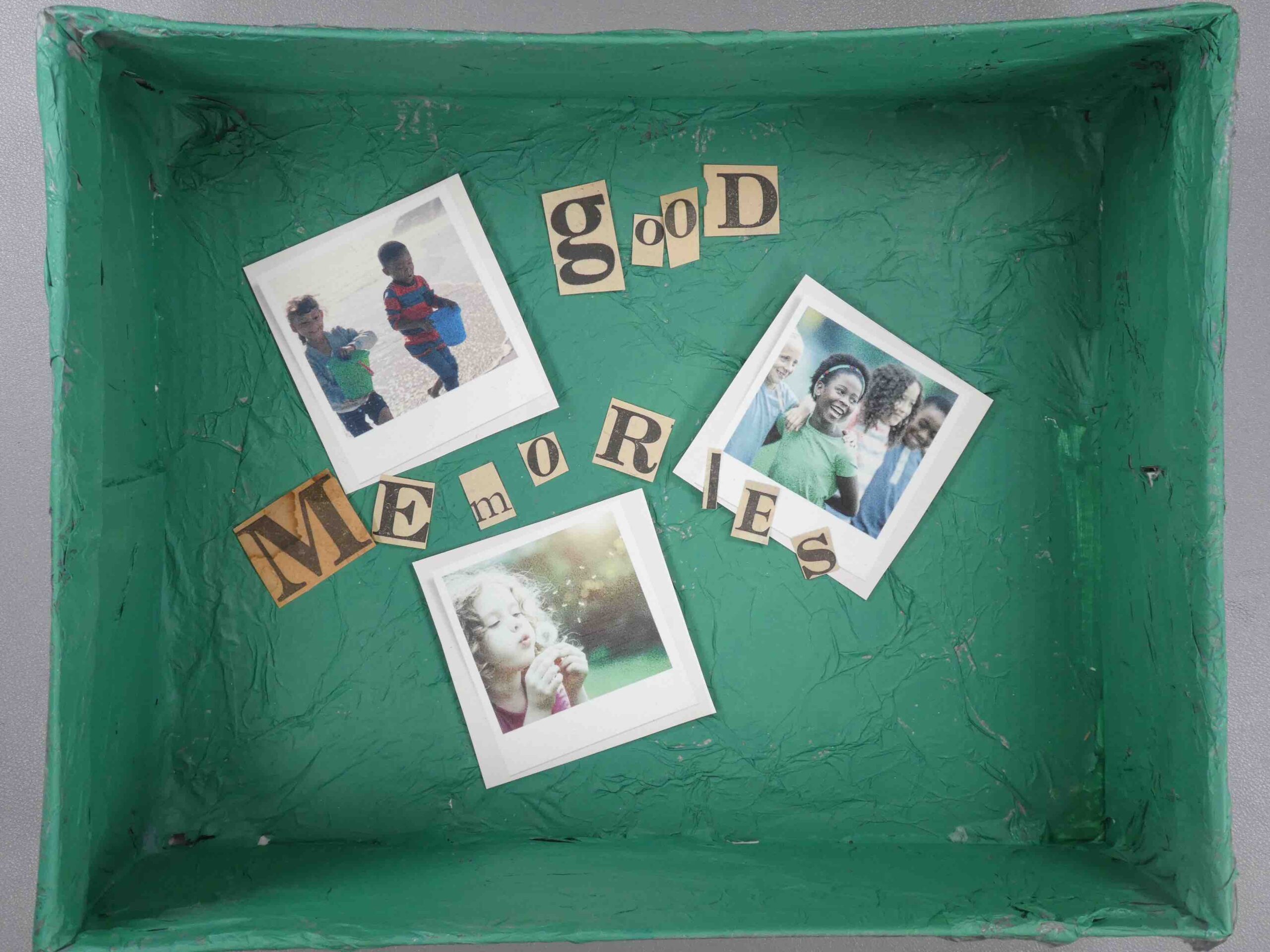 View inside a painted shoebox with pictures and the words, 'good memories' inside.