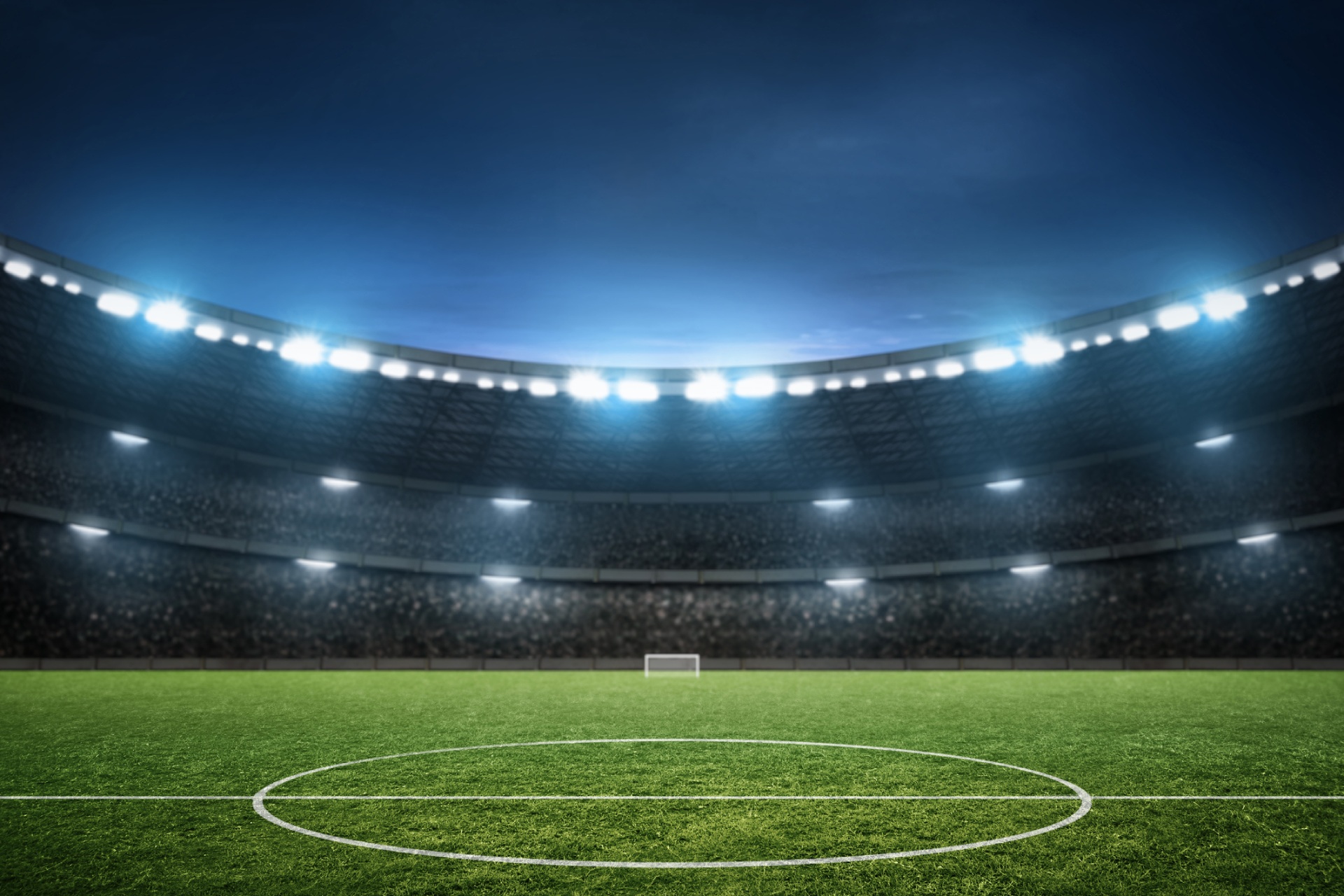 A soccer stadium illuminated at night, showcasing the field and goalposts.