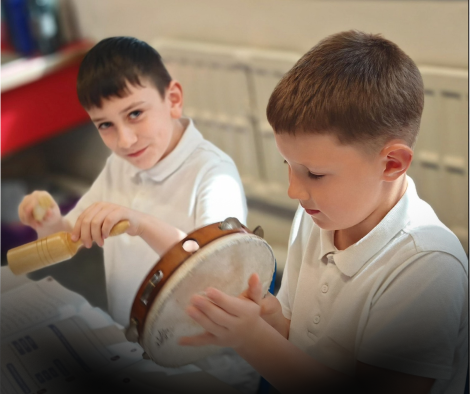 Two pupils play percussion instruments during a music lesson, with one holding a tambourine and the other using a wooden guiro.