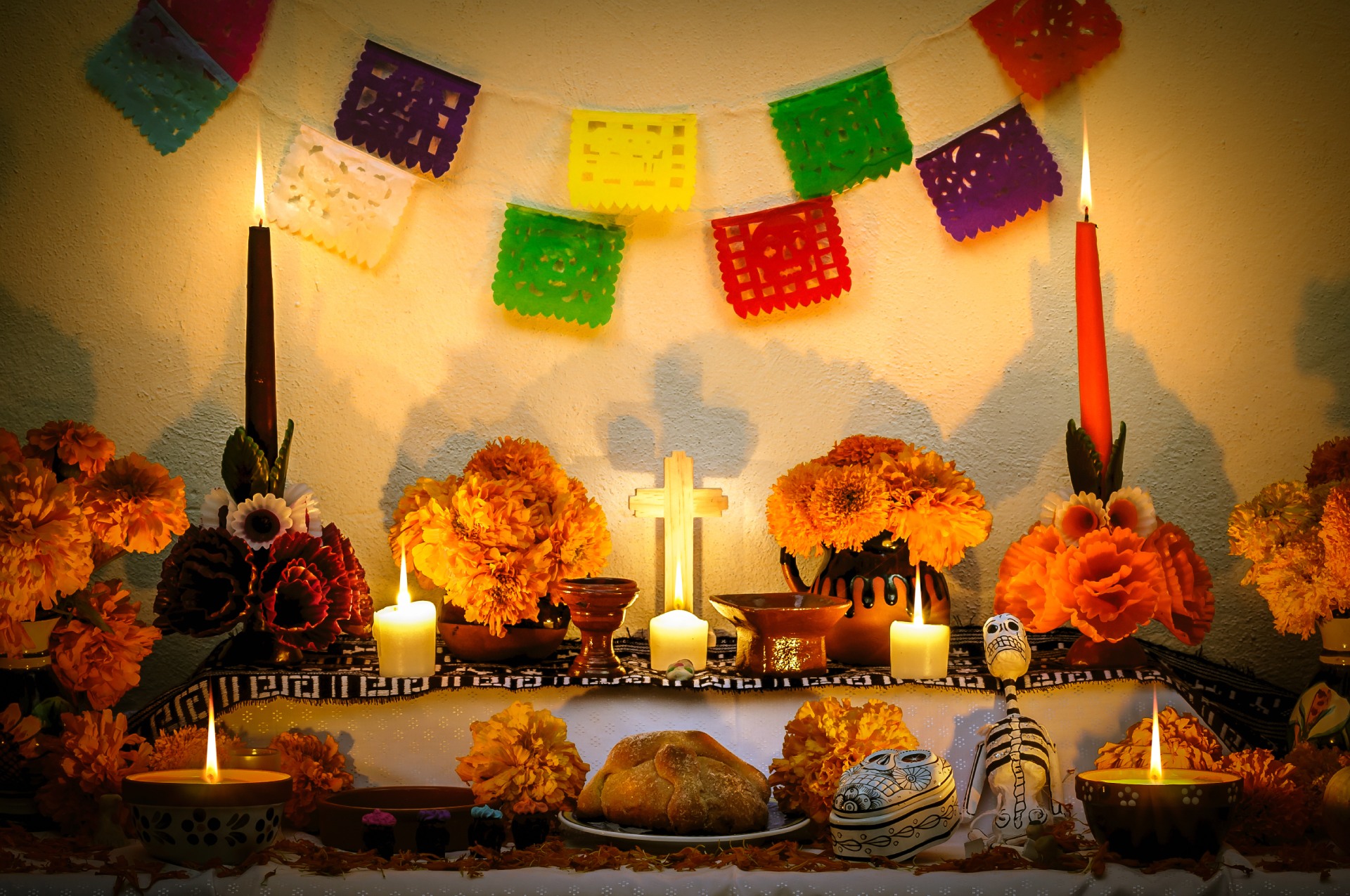 Traditional Day of the Dead altar with marigolds, candles, papel picado, and offerings