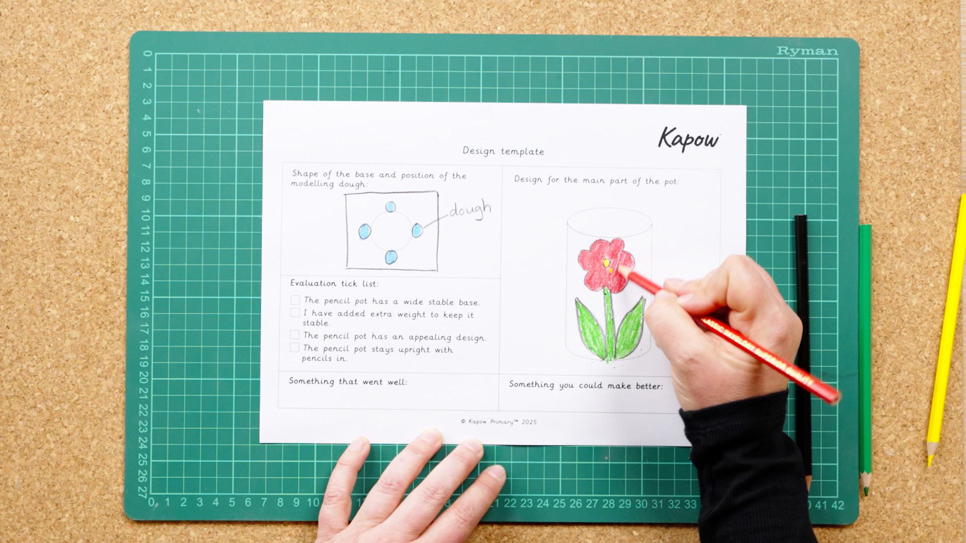 Top down photograph of a person using a design template to make a stable pencil pot.