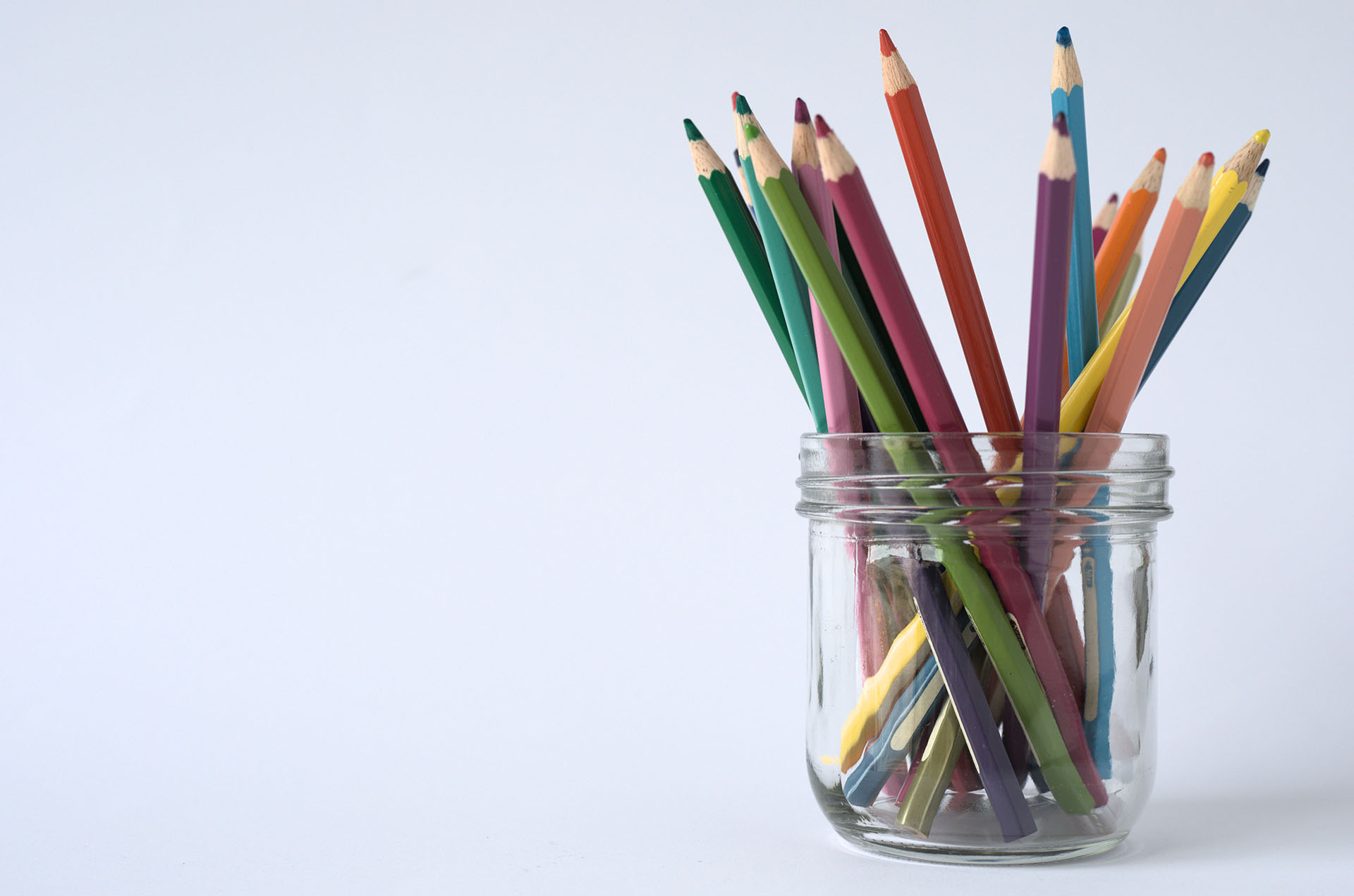 Glass jar used as a pencil pot on a white background.