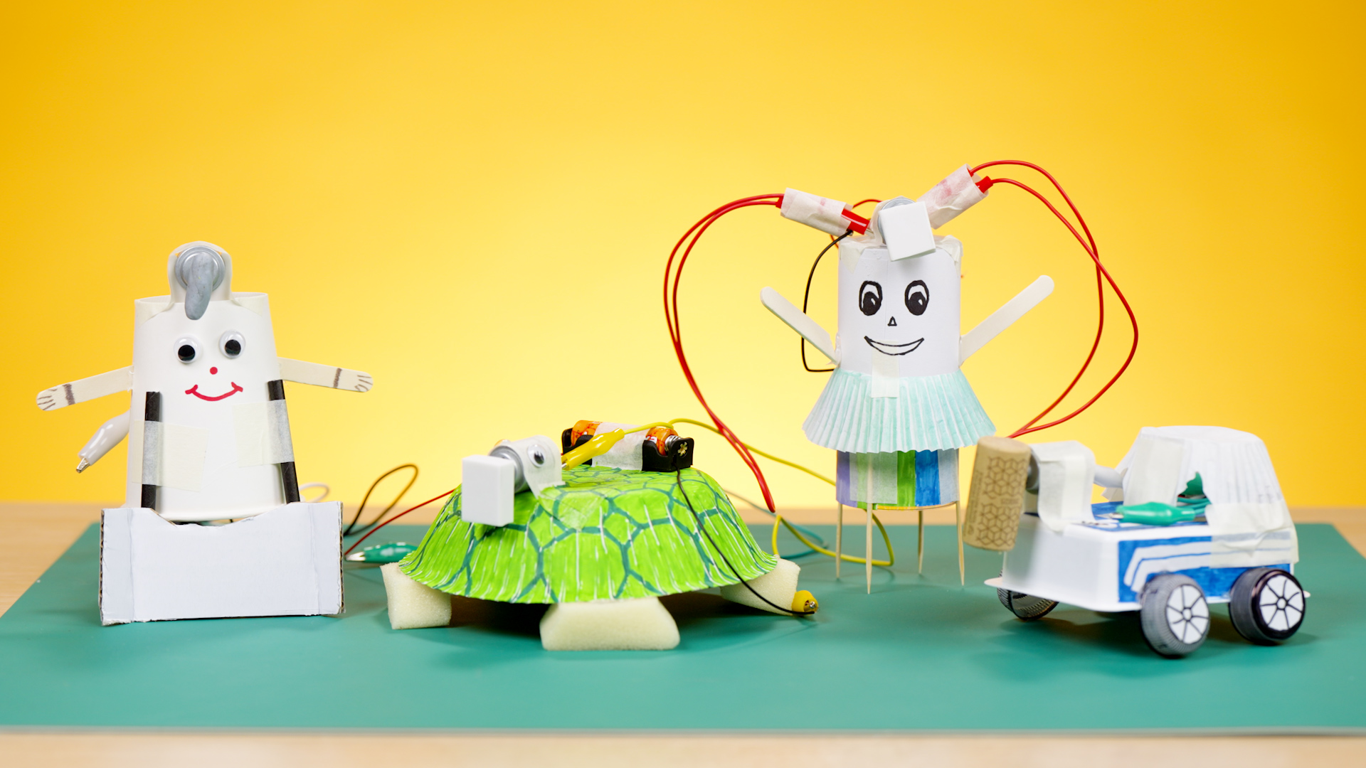 Four pupil-made motorised models including robots, a turtle, and a car crafted from recycled materials with simple circuits.