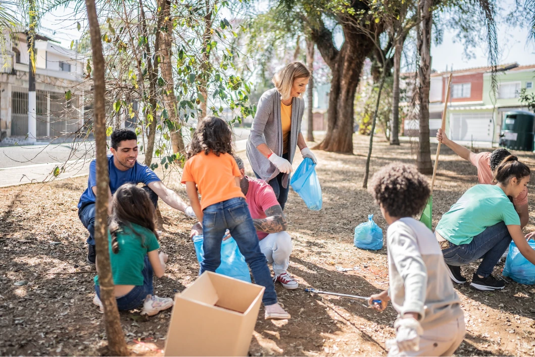 Children and adults picking up litter together in a park.