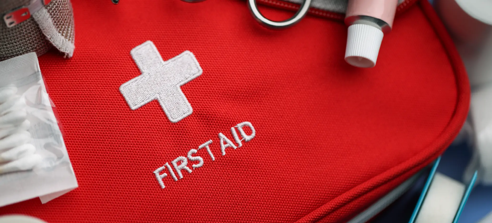 Red first aid kit with medical supplies, including bandages and antiseptic