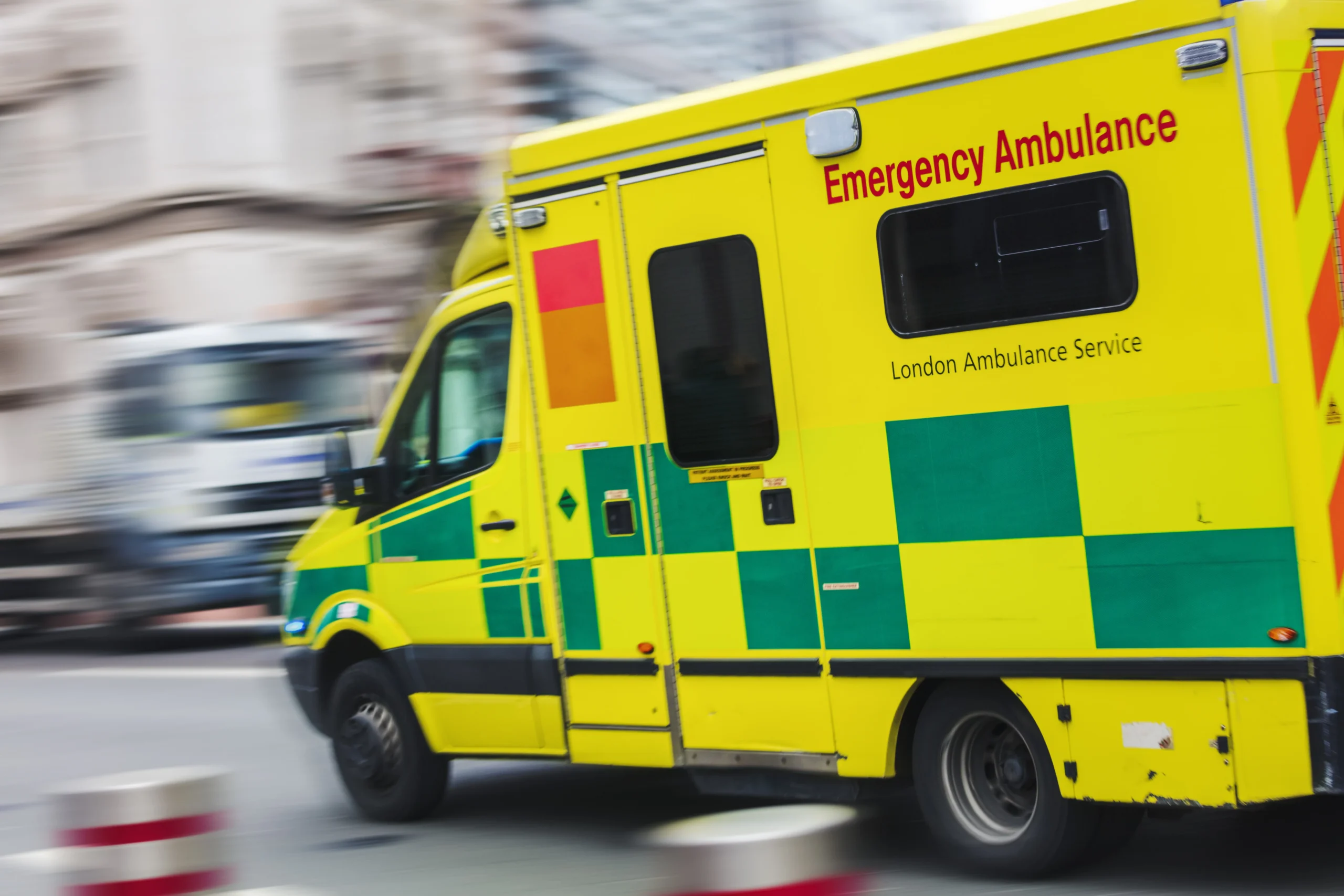 London Ambulance Service emergency ambulance travelling through a city street