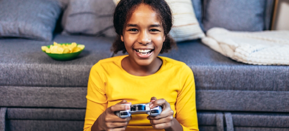 Smiling child holding a games controller at home