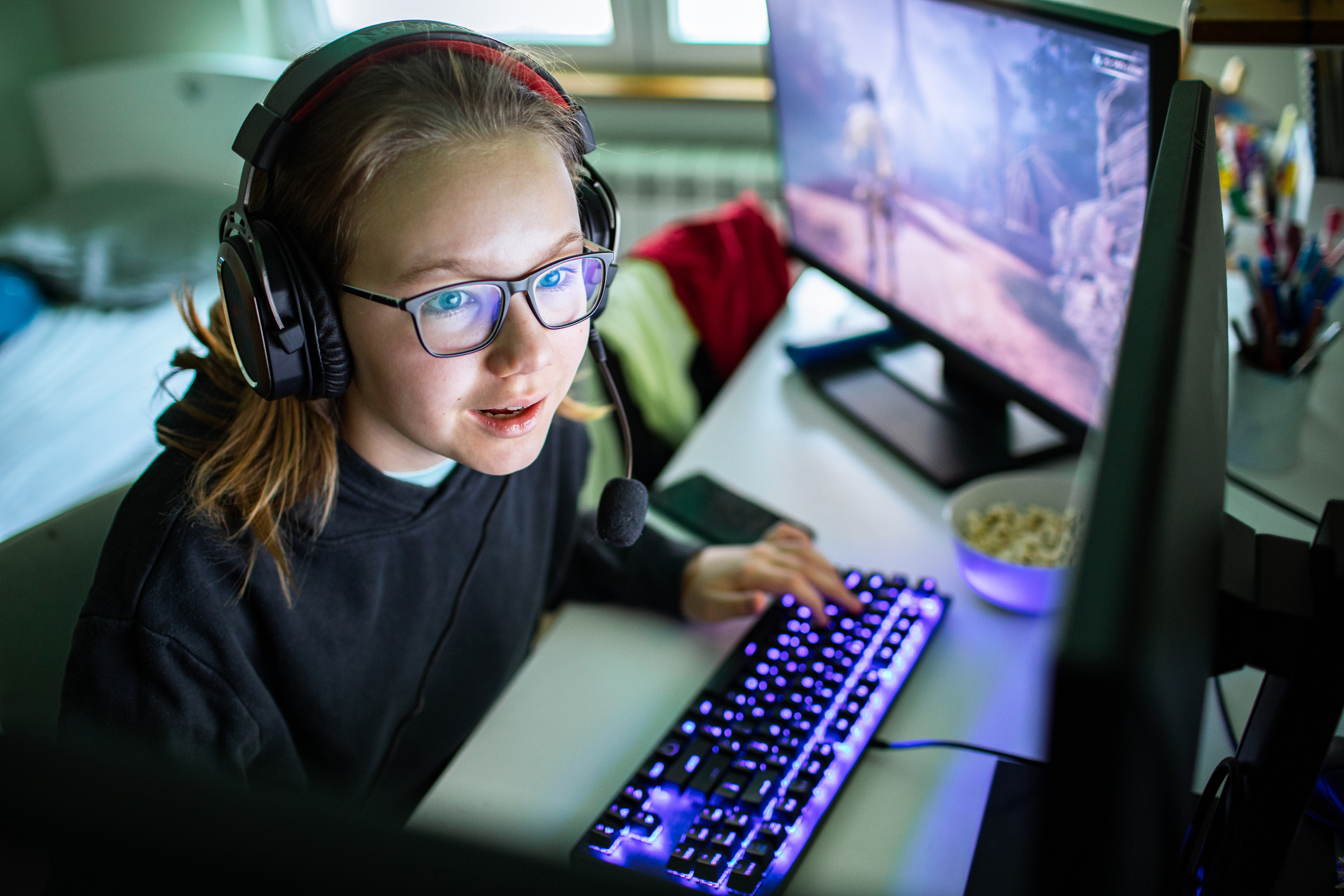 Young girl playing videos games on her desktop computer