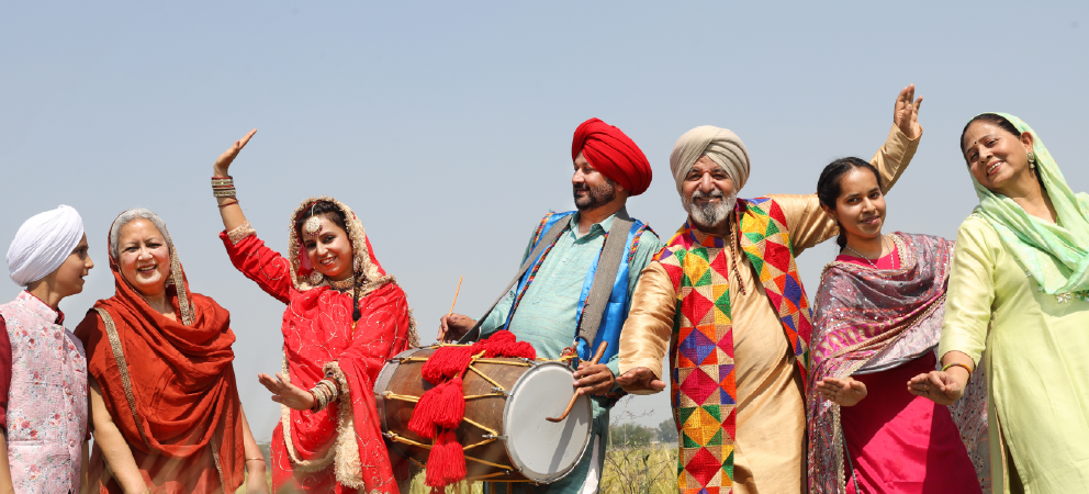 Punjabi family celebrating Baisakhi festival with bhangra music and dance.