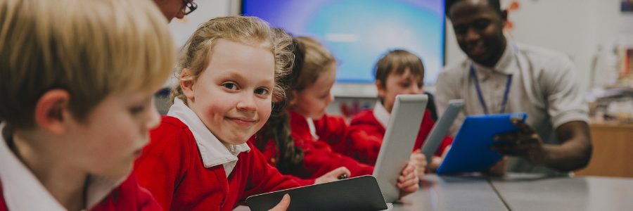 primary school pupils in a computing lesson learning on tablet devices
