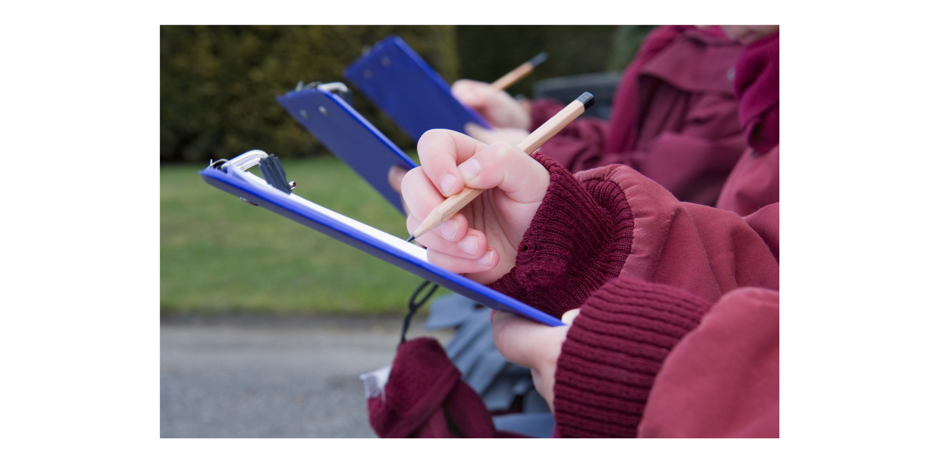 Children using clipboards in school grounds