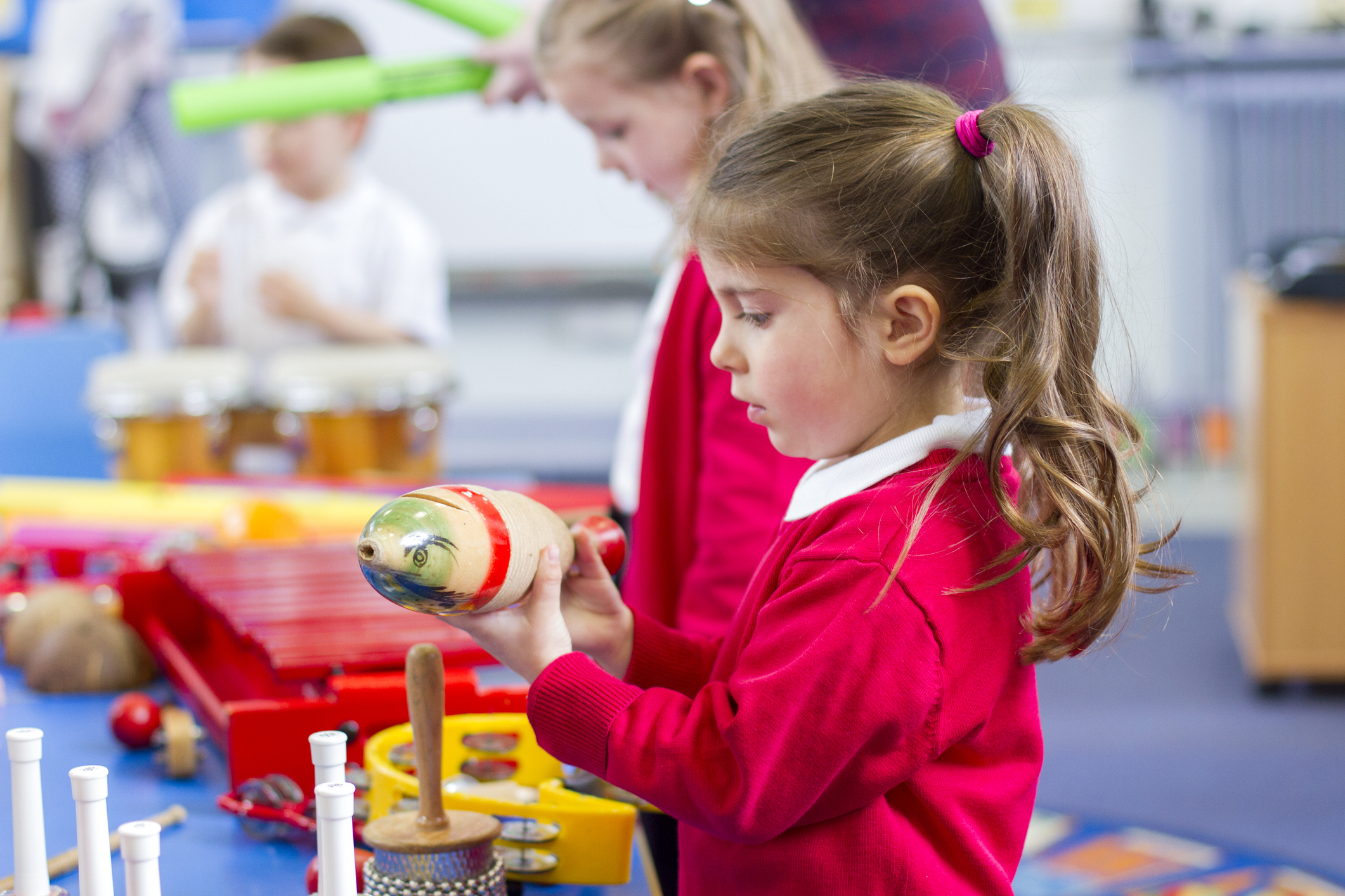 Young children exploring percussion instruments during a music lesson.