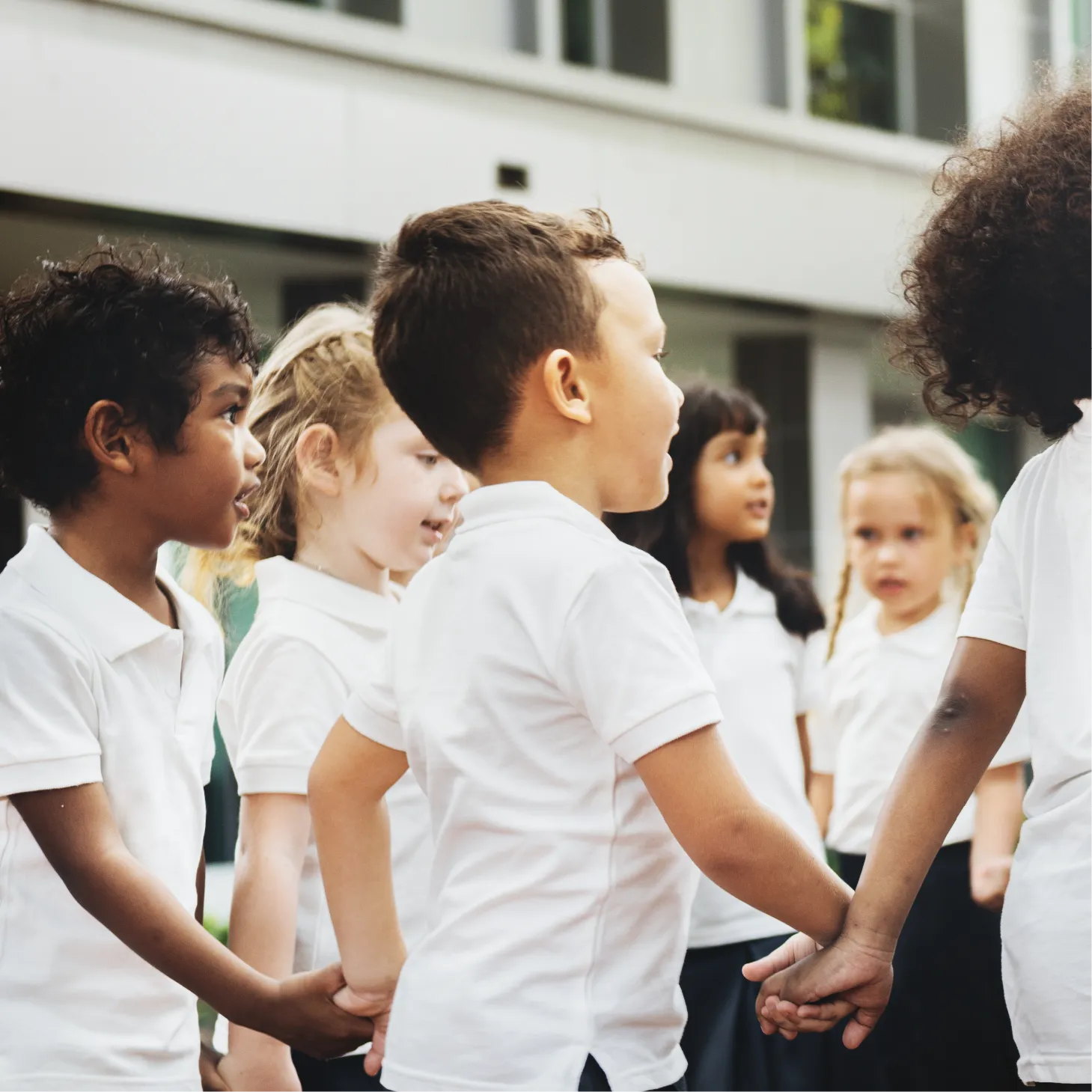Group of school children holding hands in a circle