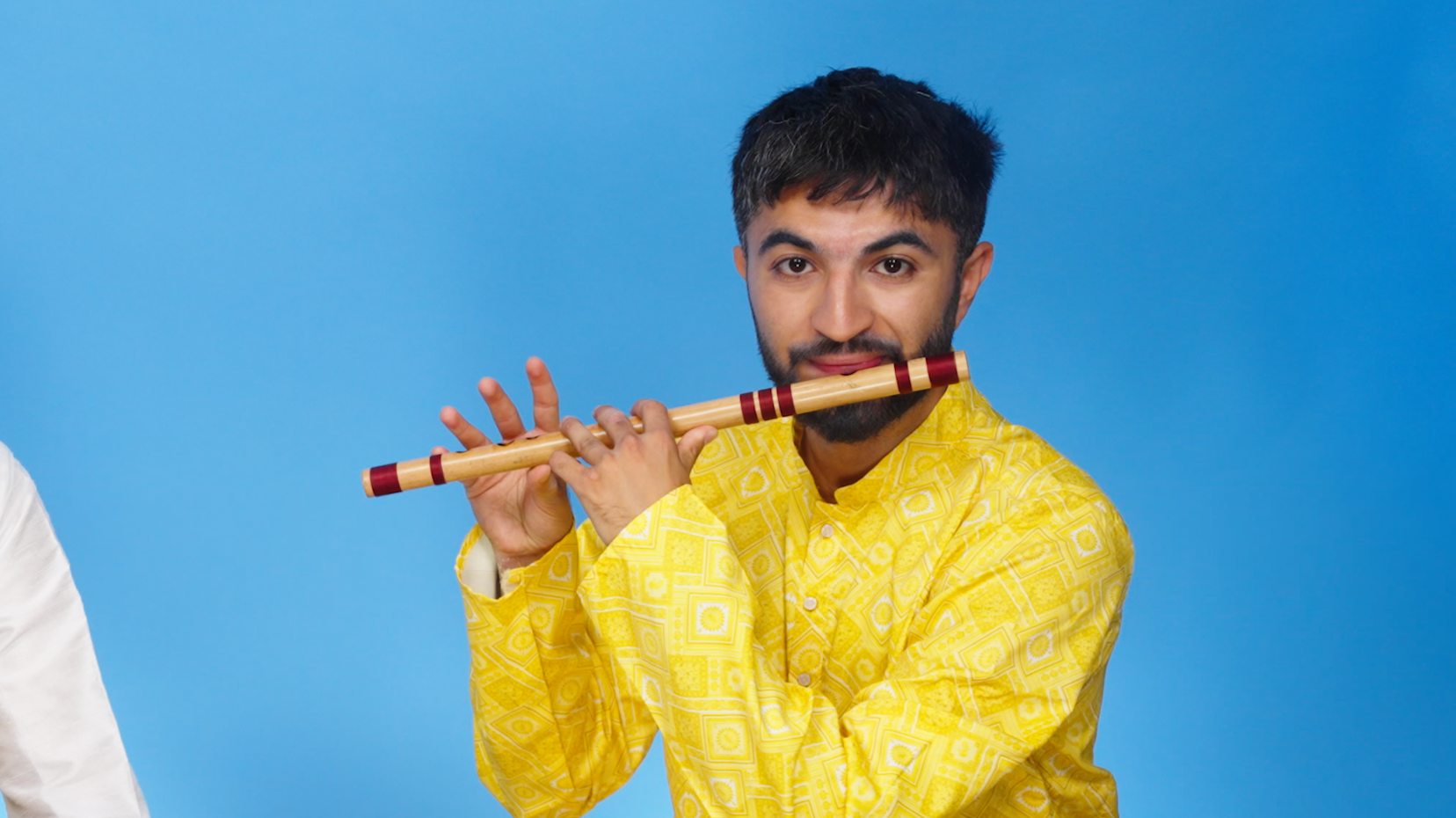 A musician plays a flute during a traditional performance.
