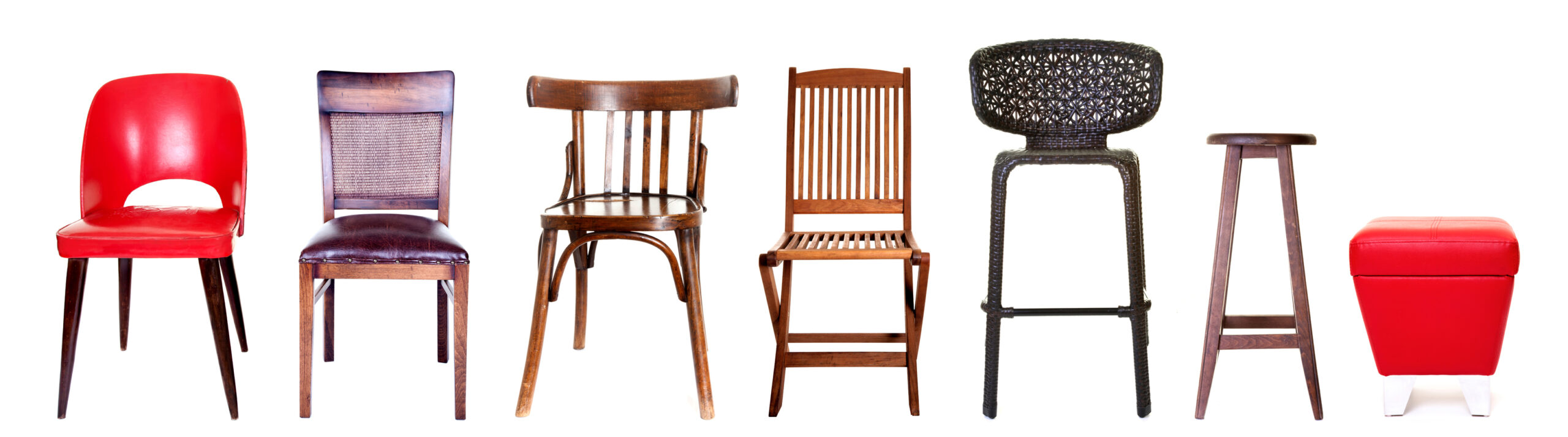 A row of seven different chairs and stools in varying styles and colours.