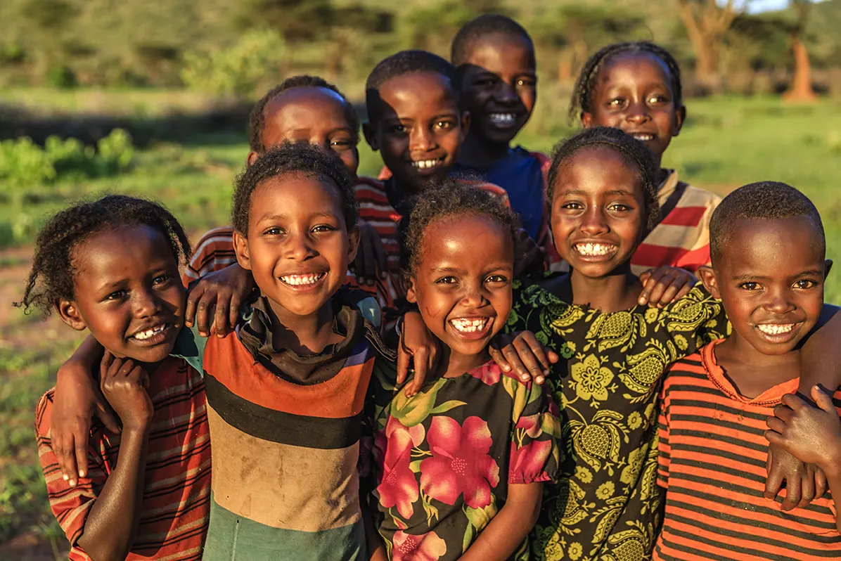Children smiling together outdoors.