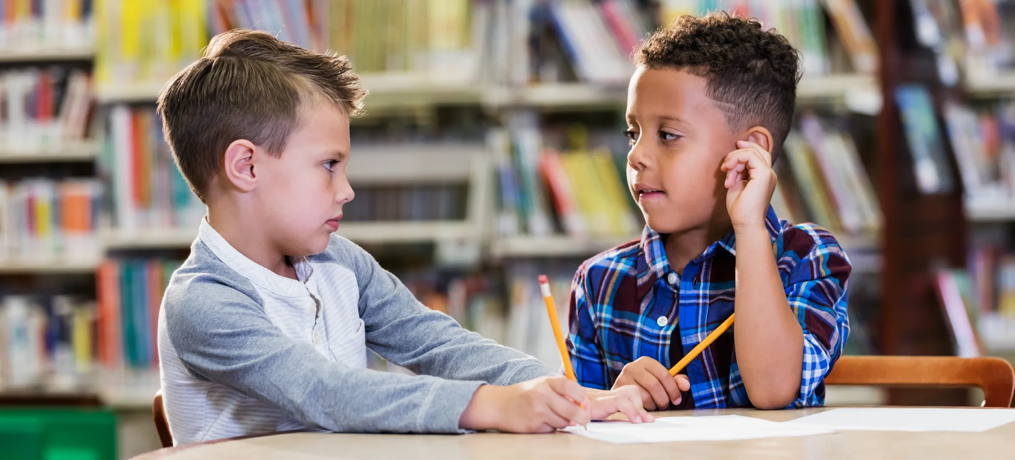 An image of two boys talking seriously, resolving a conflict