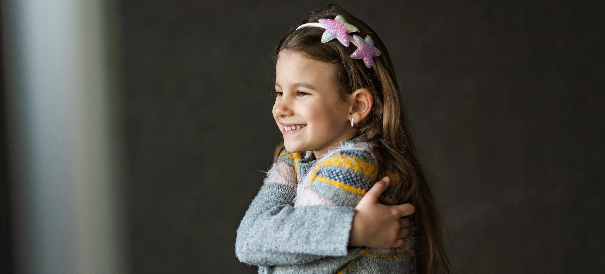 An image of a girl hugging herself, showing self-love